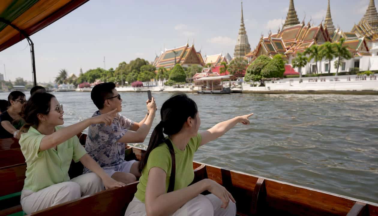 Boat passing iconic temple in Bangkok