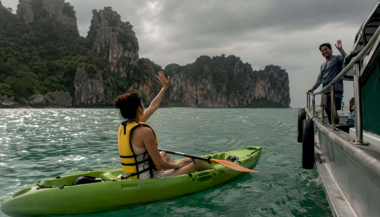 Kayaker signalling guide near support boat