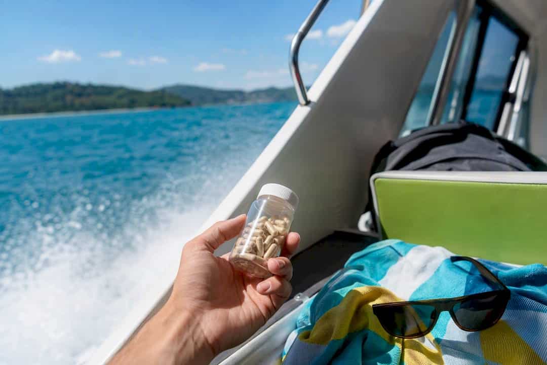 Traveler holding ginger capsules on speedboat deck