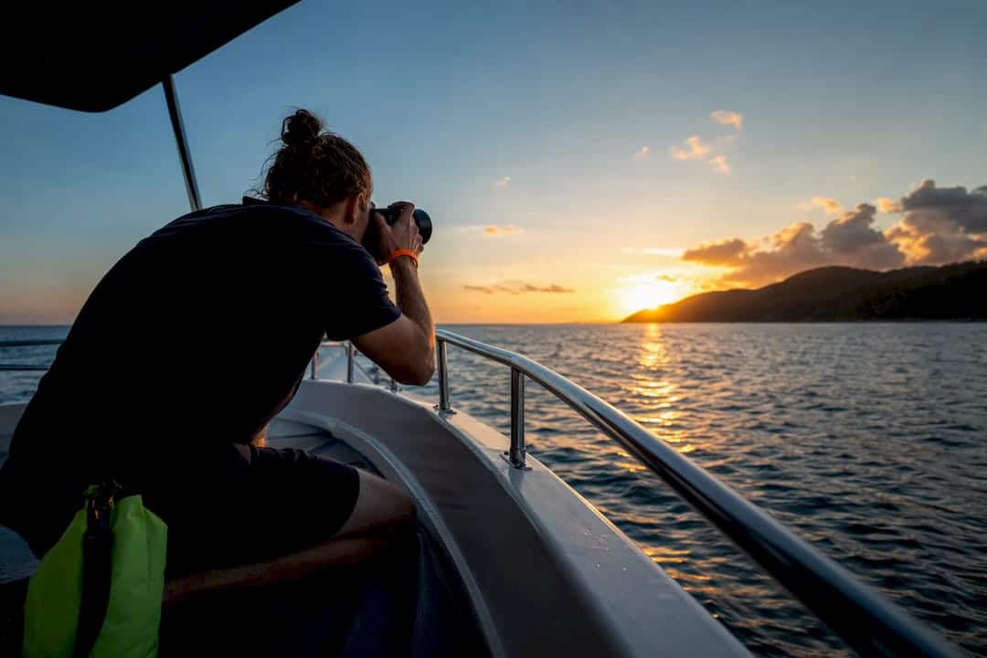 Photographer capturing Phuket sunset from boat