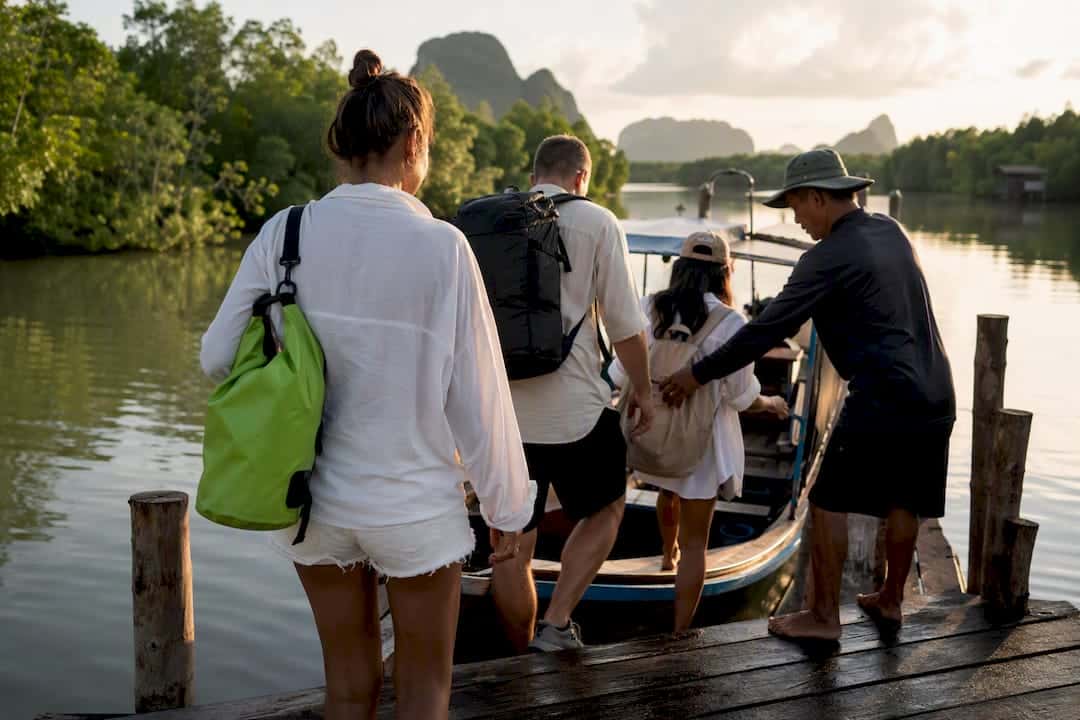 Travelers boarding an early longtail boat