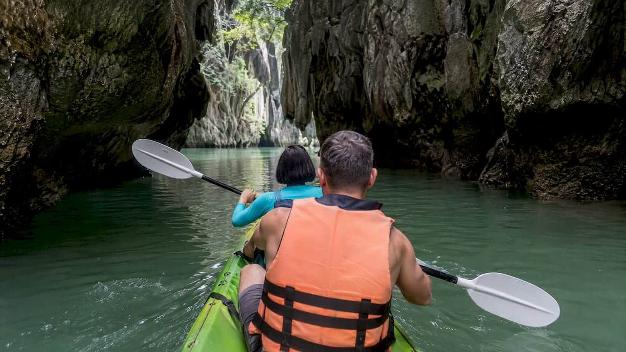 Kayakers entering a quiet limestone hong