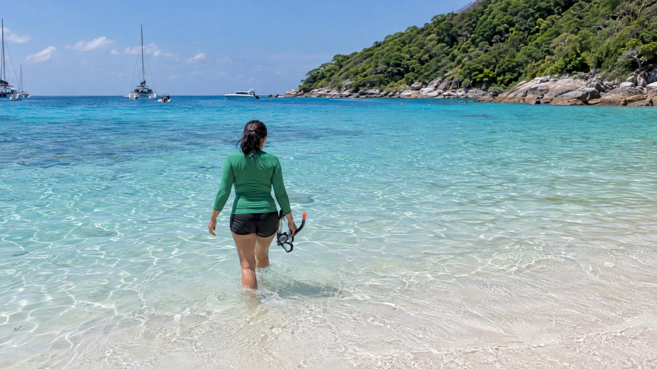 Snorkeler wading into Racha Yai's clear bay