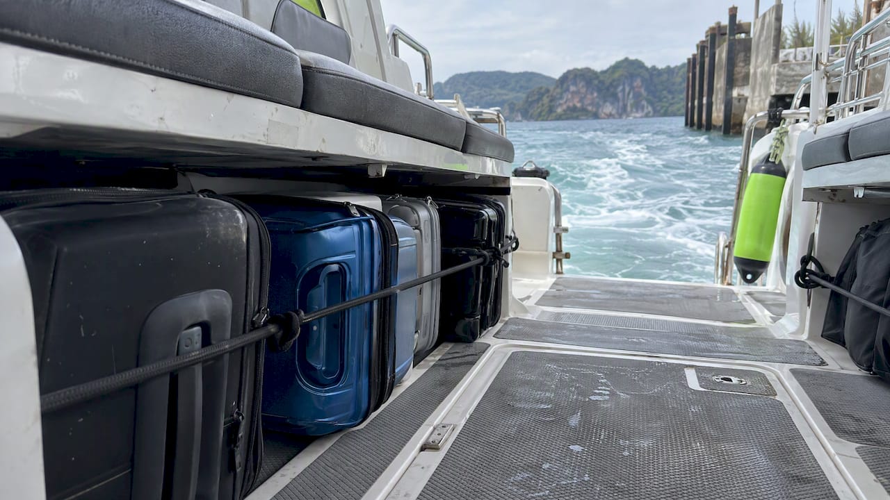 Suitcases stacked beneath seats on a speedboat