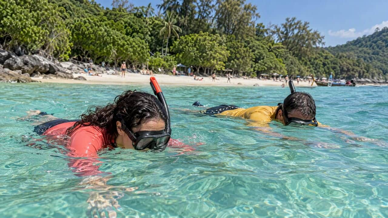 Travelers snorkel in Coral Island shallows